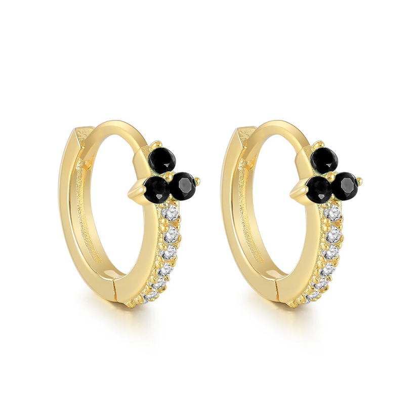 A pair of gold-colored hoop earrings with black stone detailing and attached to a white background.