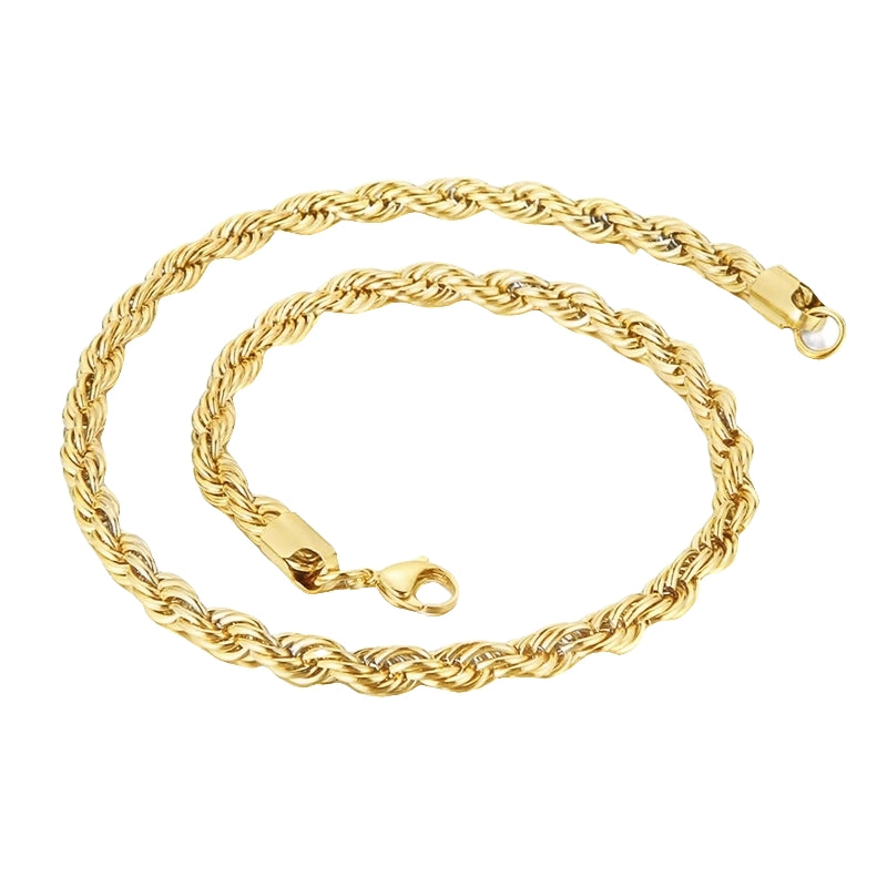 A gold chunky statement chain necklace laid out on a plain surface.