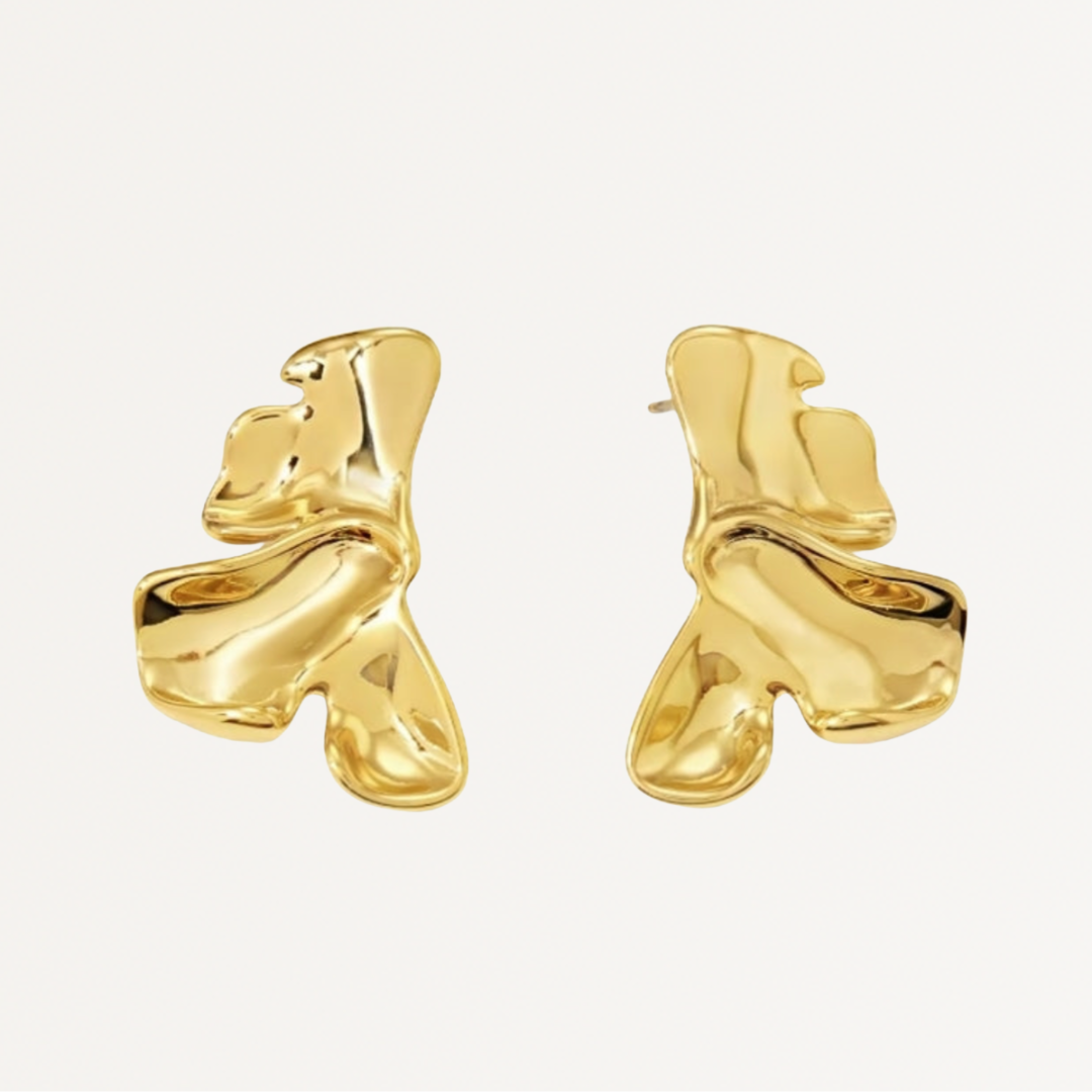 Gold abstract earrings on a light gray background