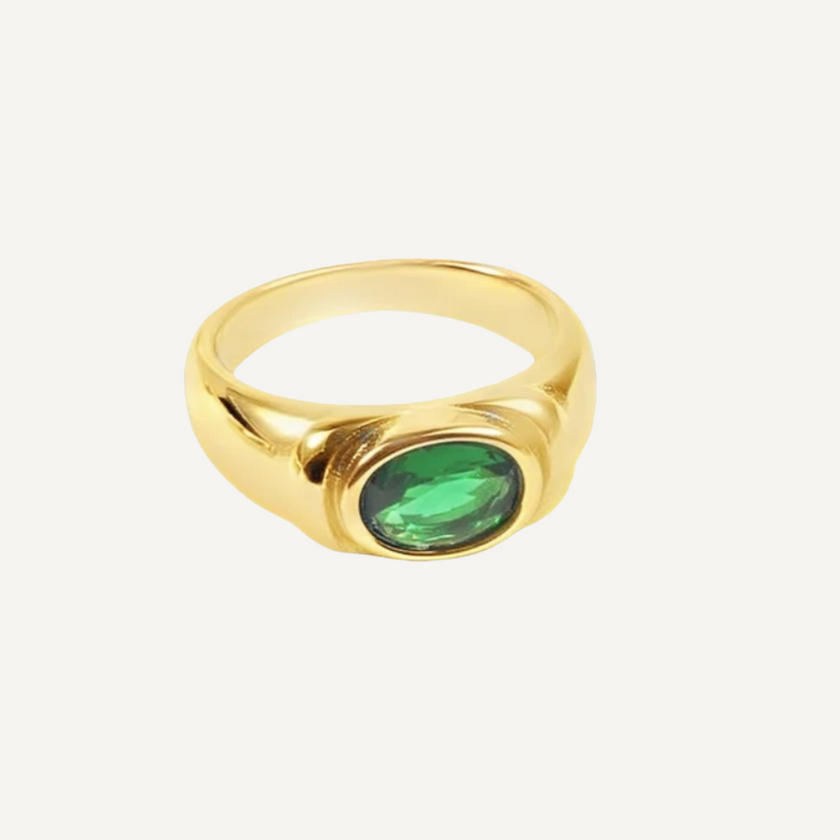 Gold ring with a green gemstone on a white background