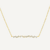 Gold necklace with small diamonds on a light gray background