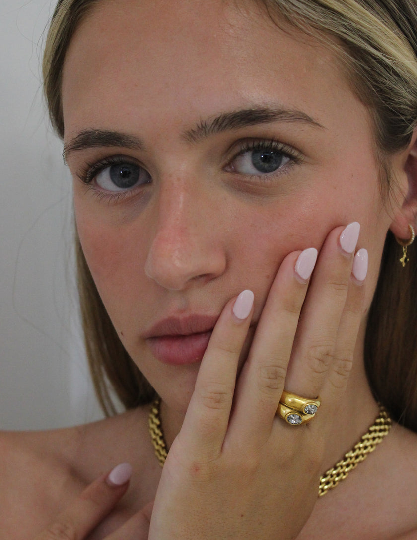 Teall Jewellery gold statement ring with two stacked bands and offset oval white gemstones, bold and modern design on a white background