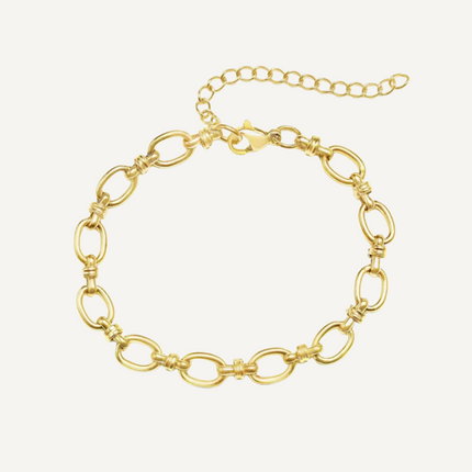 Gold chain bracelet on a light beige background