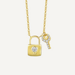 Gold necklace with lock and key pendants on a light gray background