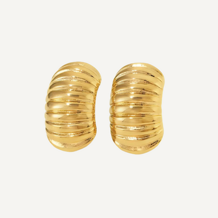 Pair of gold earrings on a light beige background