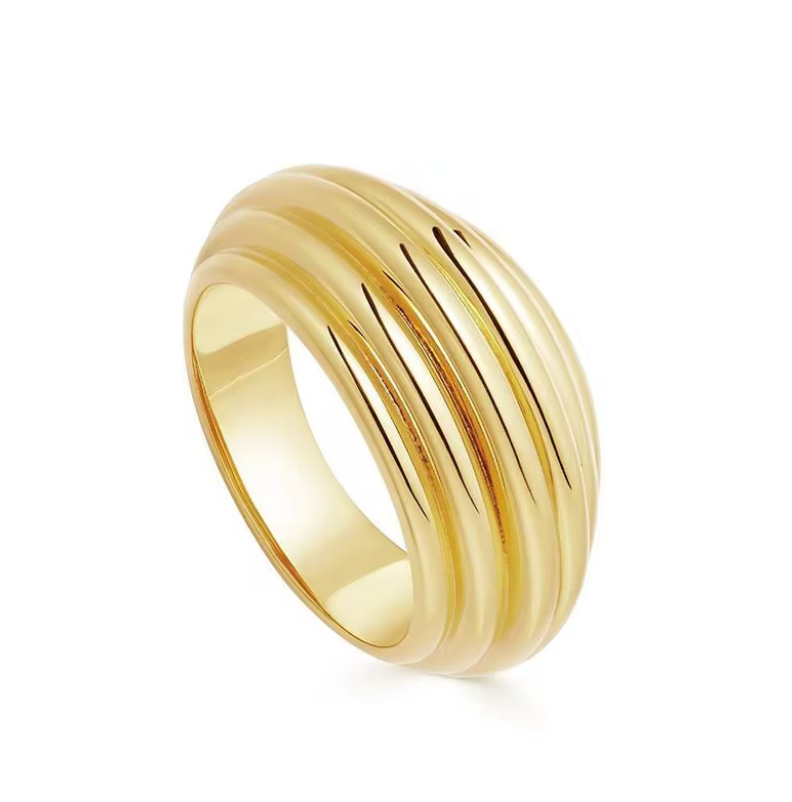 Gold ribbed textured ring on beige background 