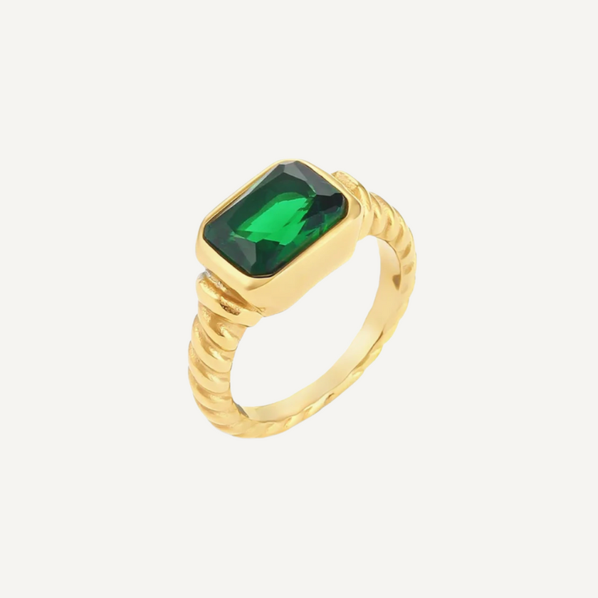 Gold ring with a green gemstone on a white background