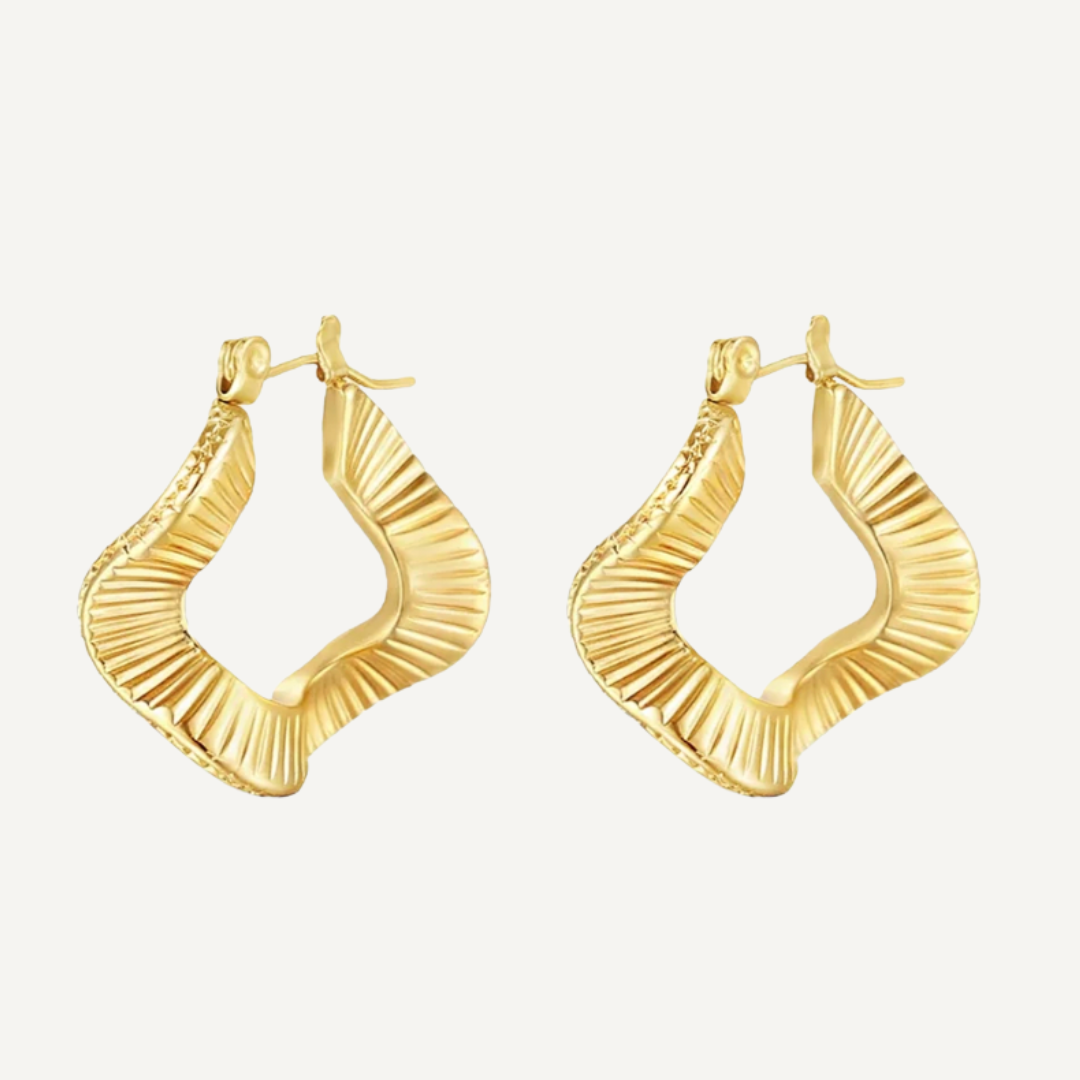 Gold hoop earrings on a light beige background