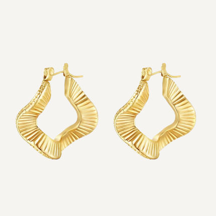 Gold hoop earrings on a light beige background