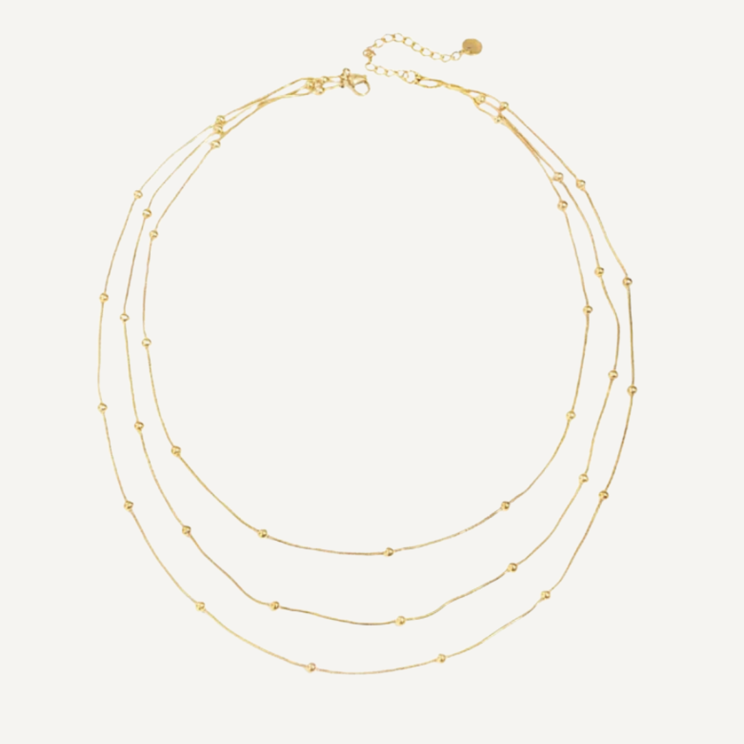 Gold necklace with multiple strands on a white background
