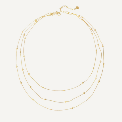 Gold necklace with multiple strands on a white background