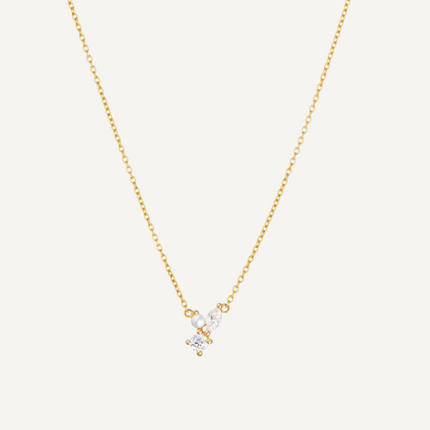 Gold necklace with a small pendant on a light gray background