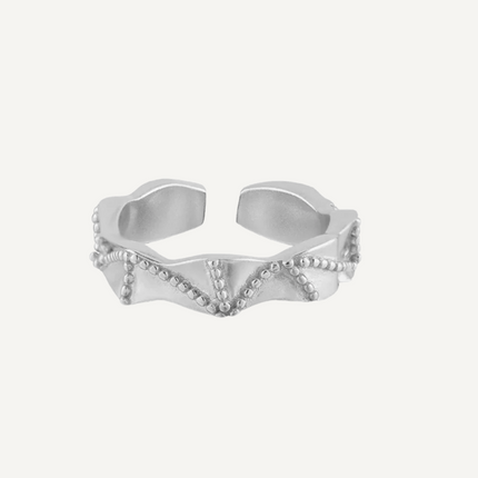 Silver ring with a shell design on a white background