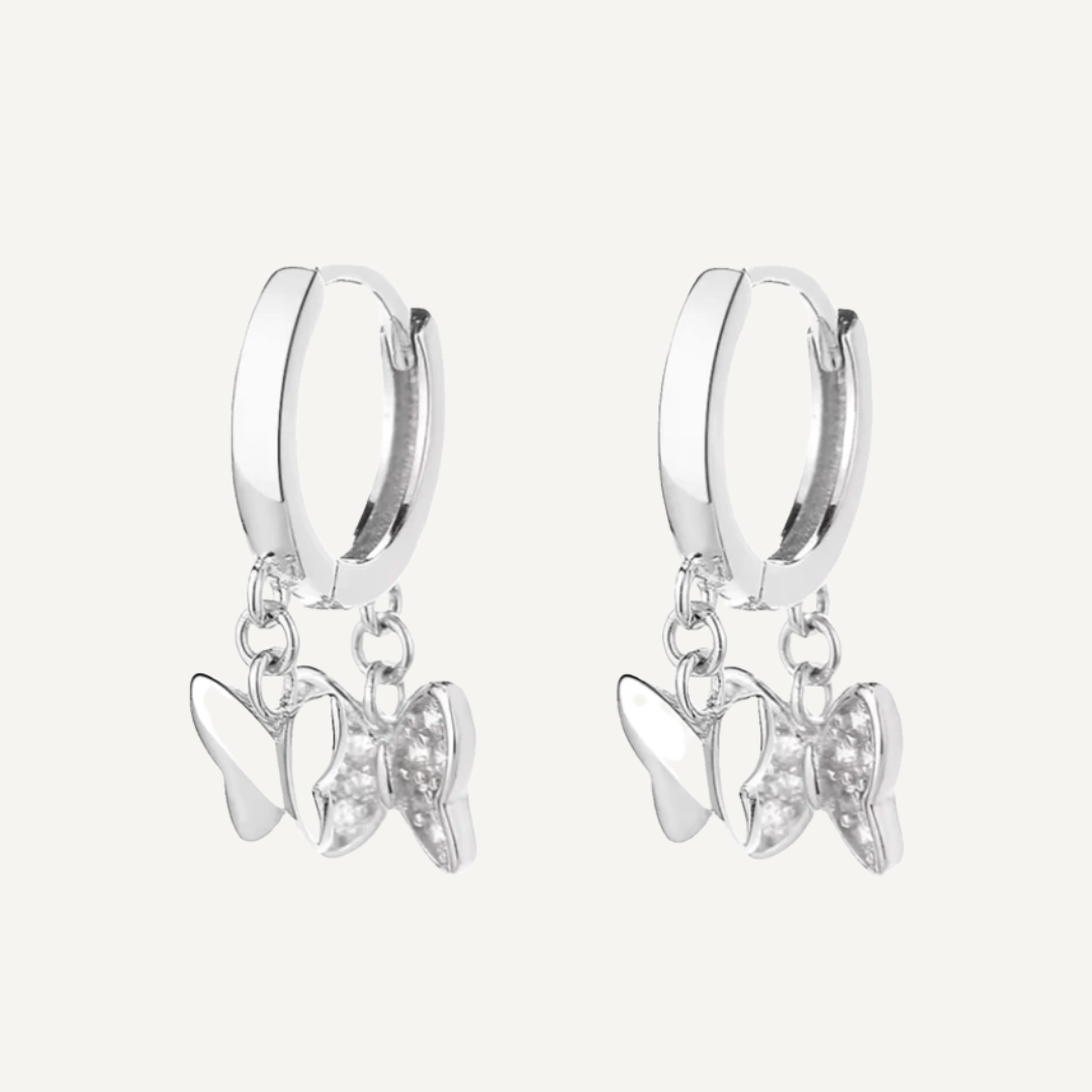 Silver hoop earrings with butterfly charms on a white background