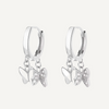 Silver hoop earrings with butterfly charms on a white background