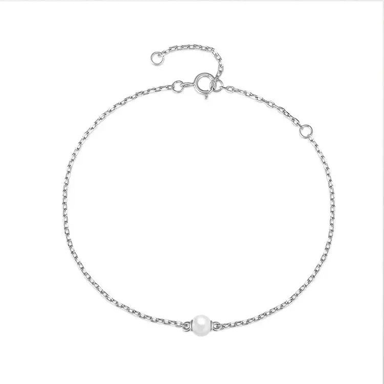 A sterling silver bracelet featuring a single freshwater pearl, with a chain of pearls adding a subtle elegance.
