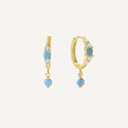 Gold hoop earrings with blue gemstones on a white background