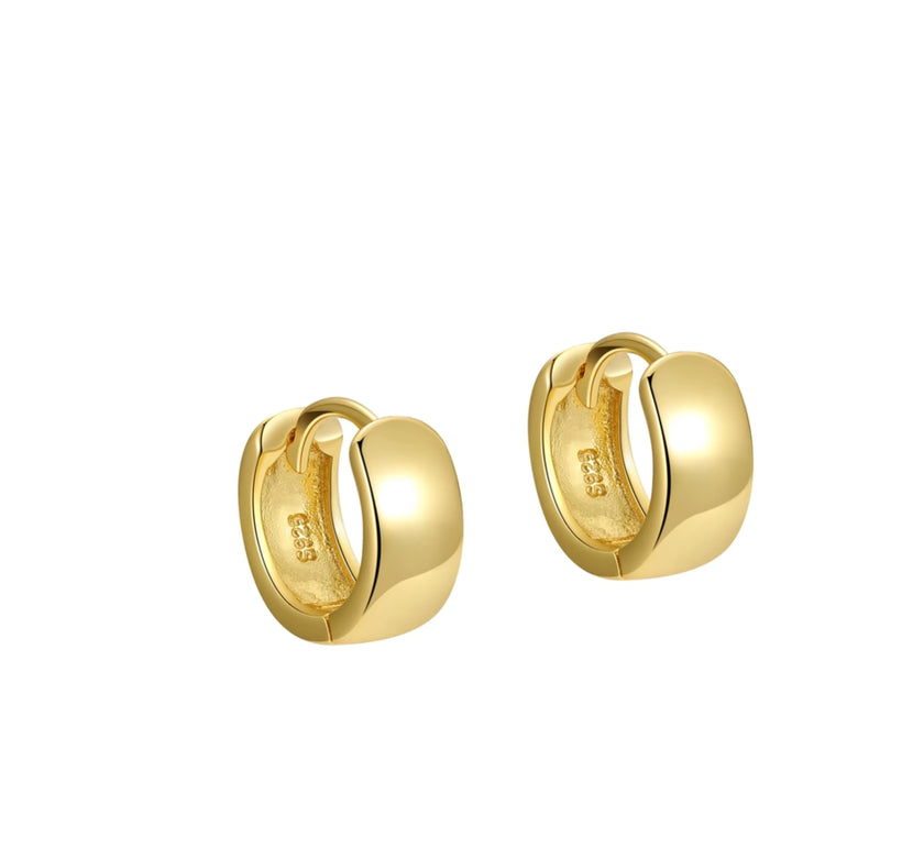 Gold huggie hoop earrings on a white background  