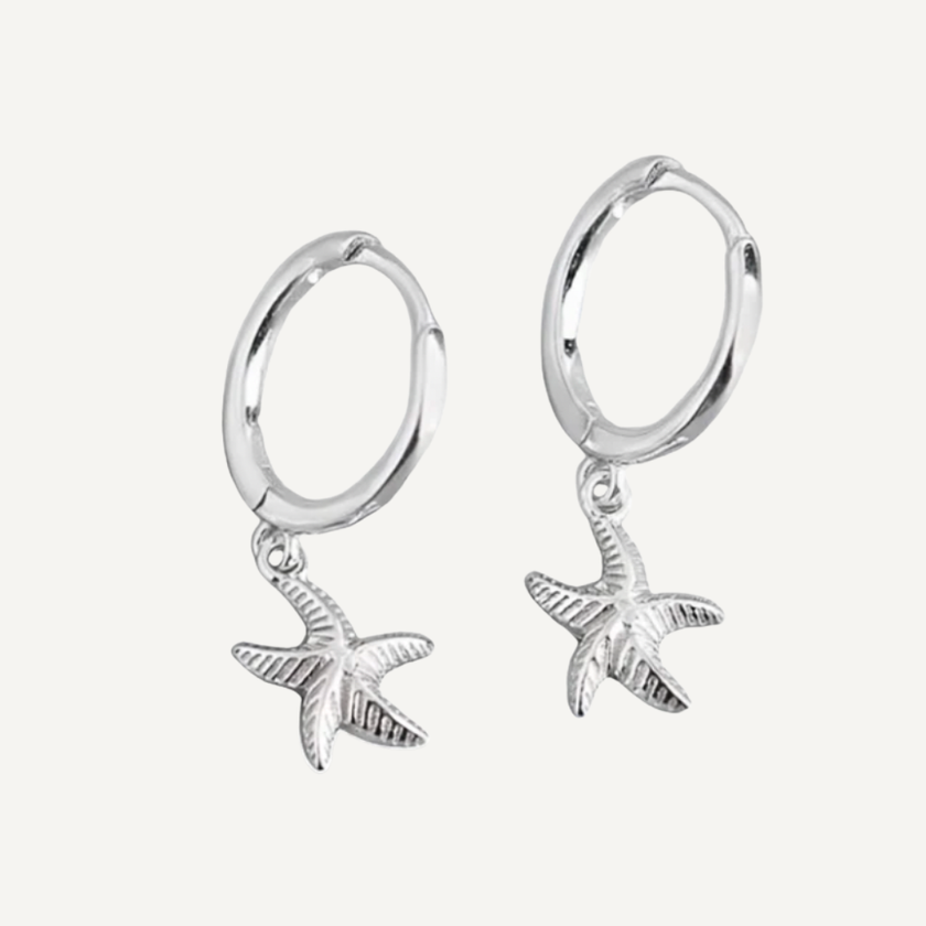 Silver hoop earrings with starfish charms on a light gray background