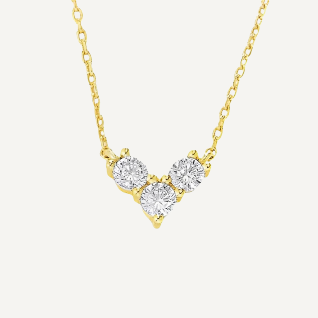 Gold necklace with three diamond-like stones on a white background
