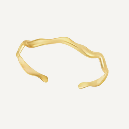 Gold bracelet on a light beige background